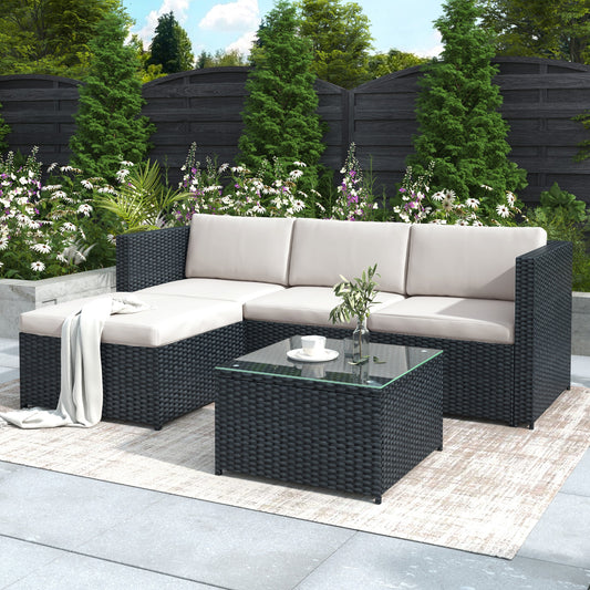 Outdoor Black Rattan patio set with a sectional sofa and coffee table in a garden setting.