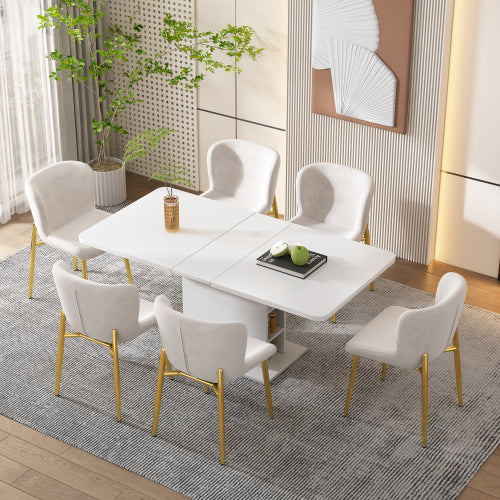 Dining room with a white table and chairs on a gray rug, plants, and artwork in the background.