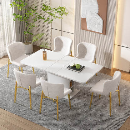 Dining room with a white table and chairs on a gray rug, plants, and artwork in the background.